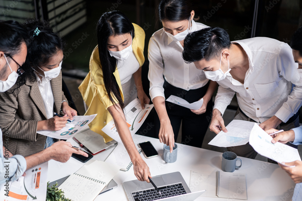 Fototapeta premium Late working of Asian business people with mask meeting in office