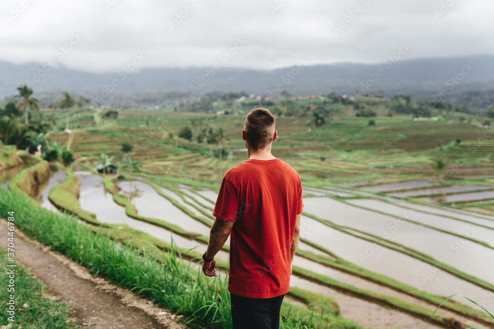 Young happy tourist enjoying the lovely view of the rice terrace in Bali, Indonesia. relaxed day in Tegalalang. Travel photograph. Lifestyle.