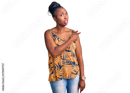 Young african american woman wearing casual clothes pointing aside worried and nervous with forefinger, concerned and surprised expression