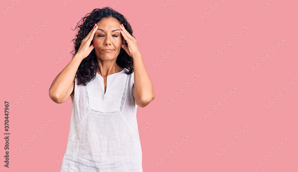 Middle age beautiful woman wearing casual sleeveless t shirt suffering from headache desperate and stressed because pain and migraine. hands on head. Middle age beautiful woman wearing casual sleeveless t shirt suffering from headache desperate and stressed because pain and migraine. hands on head.