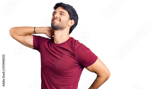 Handsome hispanic man wearing casual clothes suffering of neck ache injury, touching neck with hand, muscular pain