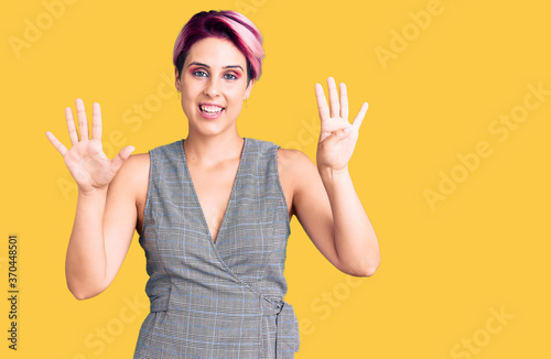 Young beautiful woman with pink hair wearing casual clothes showing and pointing up with fingers number nine while smiling confident and happy.