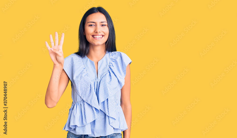 Young beautiful latin girl wearing casual clothes showing and pointing up with fingers number four while smiling confident and happy. Young beautiful latin girl wearing casual clothes showing and pointing up with fingers number four while smiling confident and happy.