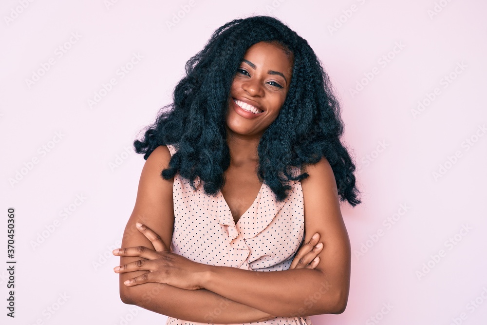 Beautiful african woman wearing casual summer clothes happy face smiling with crossed arms looking at the camera. positive person. Beautiful african woman wearing casual summer clothes happy face smiling with crossed arms looking at the camera. positive person.