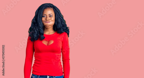 Beautiful african american woman wearing casual clothes puffing cheeks with funny face. mouth inflated with air, crazy expression.