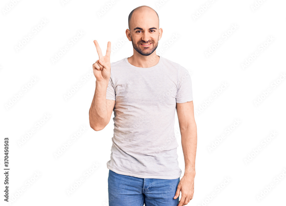 Young handsome man wearing casual t shirt showing and pointing up with fingers number two while smiling confident and happy. Young handsome man wearing casual t shirt showing and pointing up with fingers number two while smiling confident and happy.