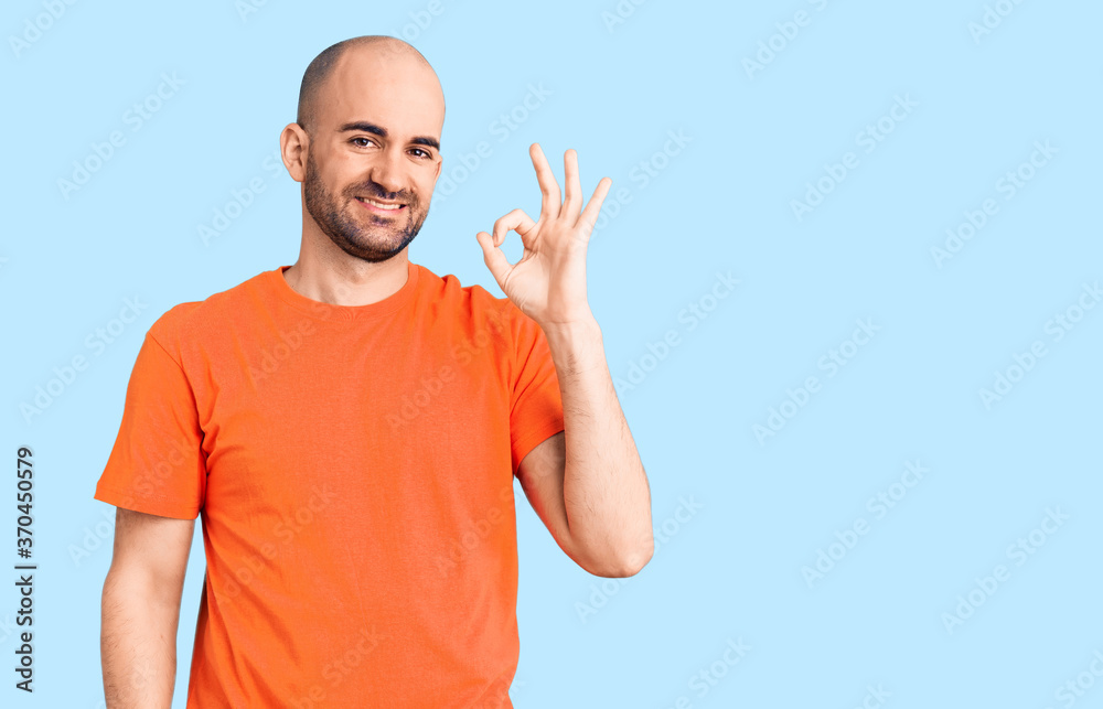 Young handsome man wering casual t shirt smiling positive doing ok sign with hand and fingers. successful expression. Young handsome man wering casual t shirt smiling positive doing ok sign with hand and fingers. successful expression.
