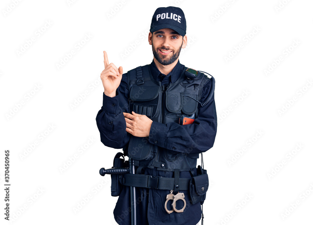Young handsome man with beard wearing police uniform with a big smile on face, pointing with hand and finger to the side looking at the camera. Young handsome man with beard wearing police uniform with a big smile on face, pointing with hand and finger to the side looking at the camera.