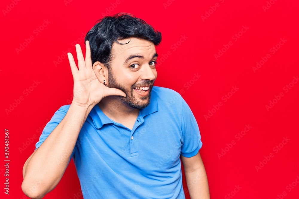 Young hispanic man wearing casual clothes smiling with hand over ear listening and hearing to rumor or gossip. deafness concept.