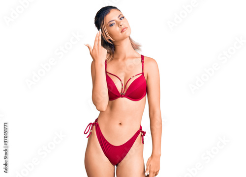 Young beautiful woman wearing bikini shooting and killing oneself pointing hand and fingers to head like gun, suicide gesture. © Krakenimages.com