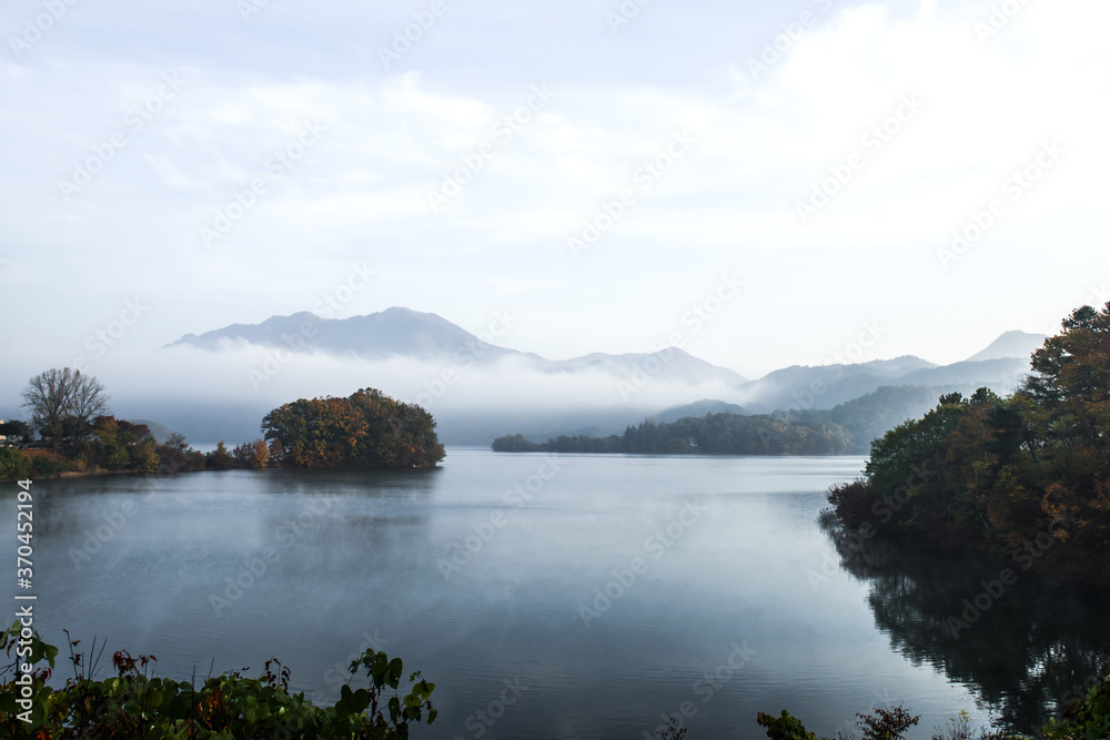 Beautiful autumn scenery, water mist over the lake and sea clouds on the mountain at dawn.