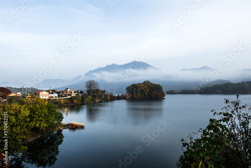Beautiful autumn scenery, water mist over the lake and sea clouds on the mountain at dawn. © Chongbum Thomas Park