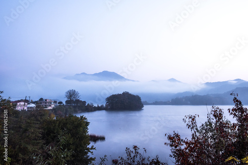 Beautiful autumn scenery, water mist over the lake and sea clouds on the mountain at dawn.