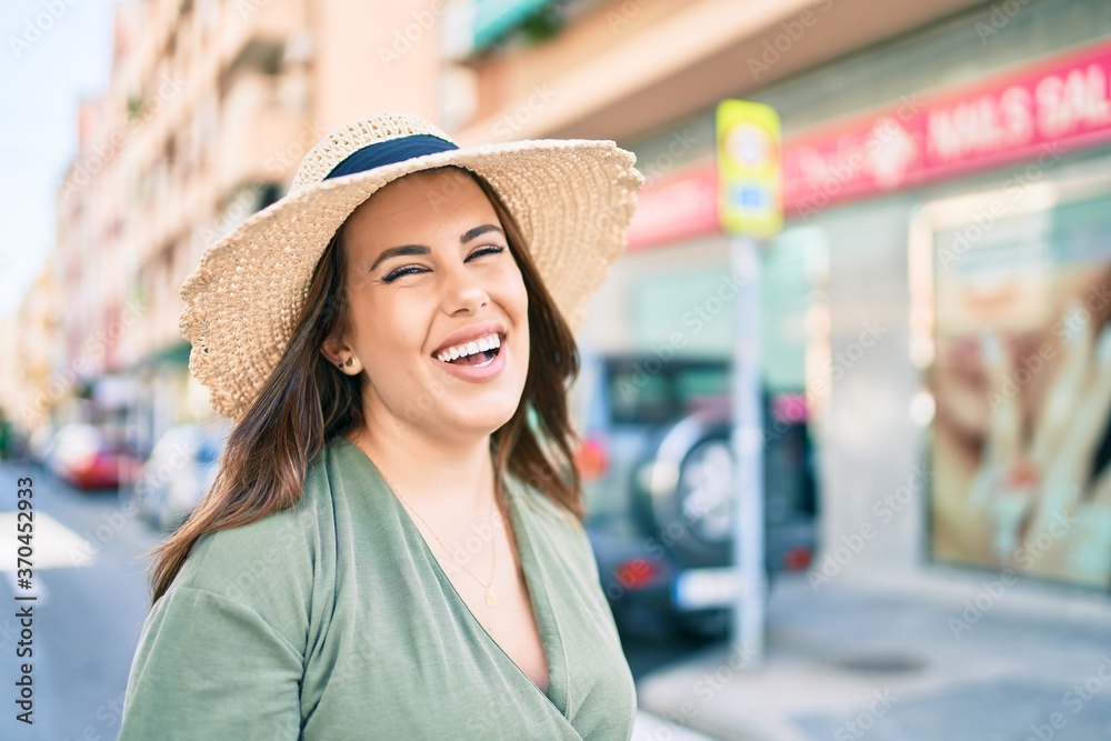 Young hispanic woman on vacation smiling happy walking at street of city