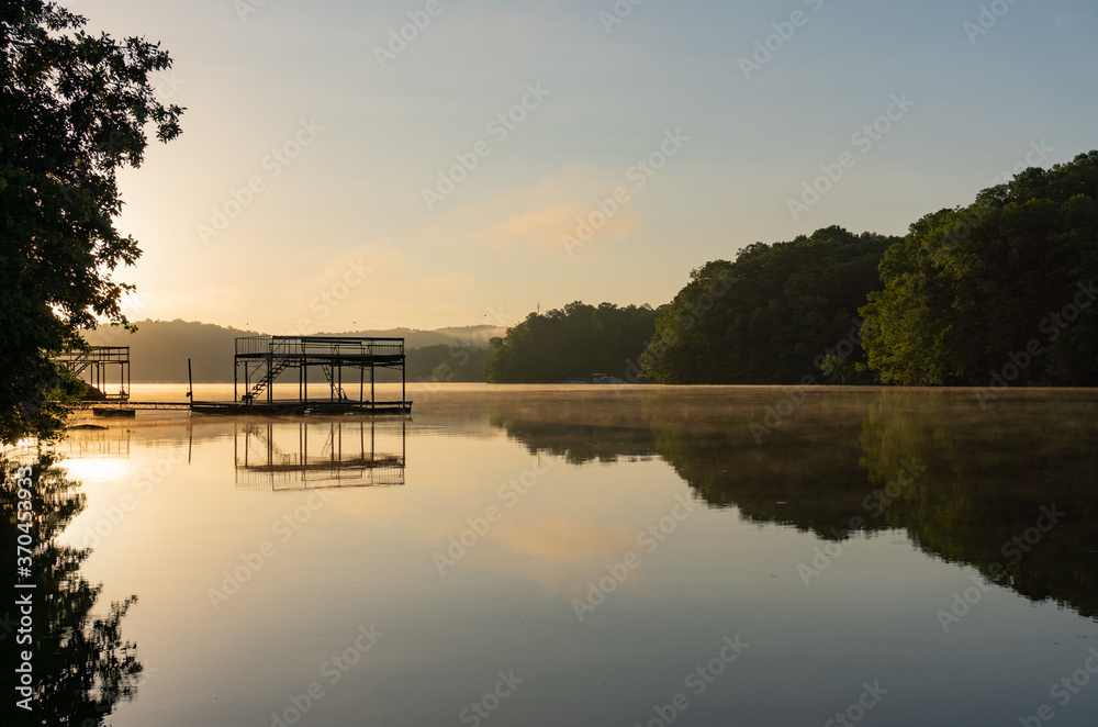 Fog on Lake Lanier in Georgia at sunrise with the silhouette of a dock