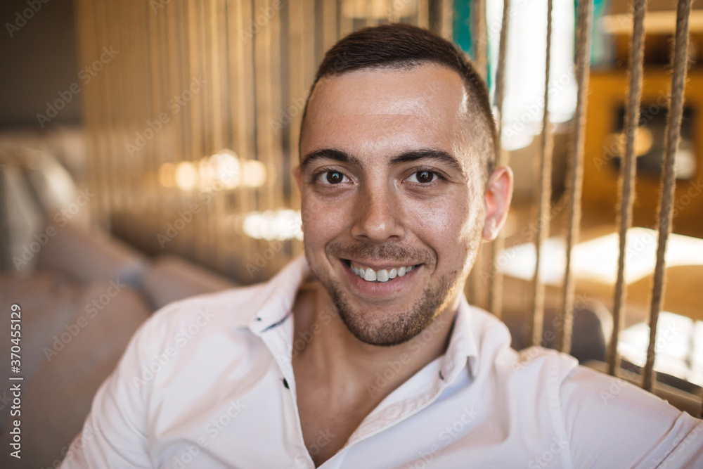 Obraz premium The young man smile in a modern stylish cafe.