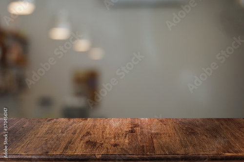 Fototapeta Naklejka Na Ścianę i Meble -  Empty dark wooden table in front of abstract blurred bokeh background of restaurant . can be used for display or montage your products.Mock up for space.