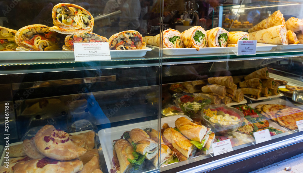 Assortment of rolls, pizza and sandwiches in shop showcase in Venice