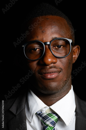 Young African businessman wearing suit in the dark