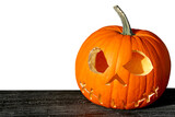Spooky Halloween pumpkin with carved creepy smiling face. White background.