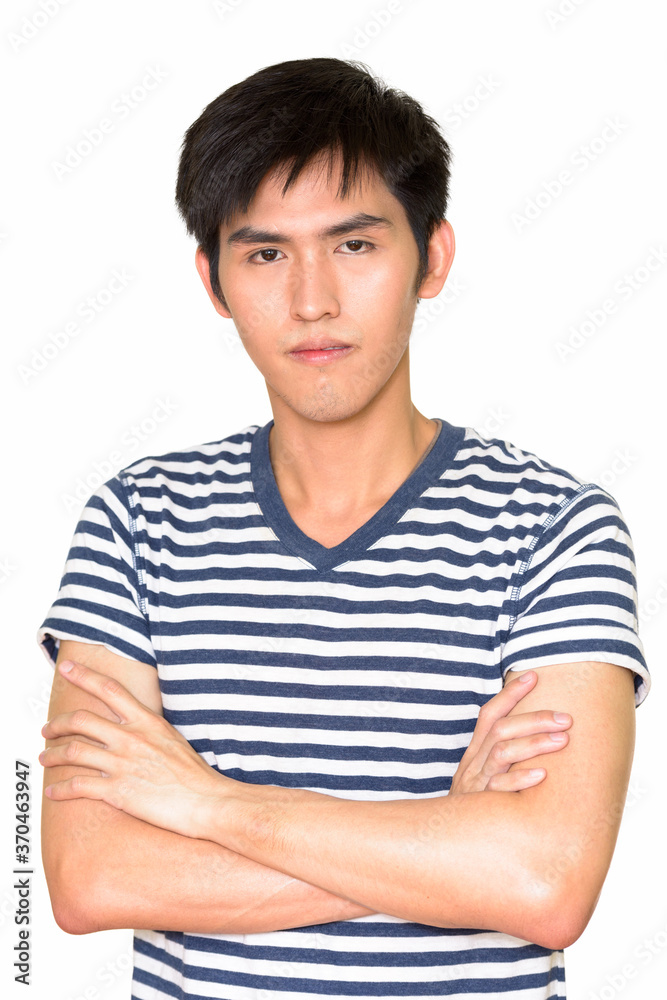 Studio shot of young handsome Asian man with arms crossed against white background Studio shot of young handsome Asian man with arms crossed against white background