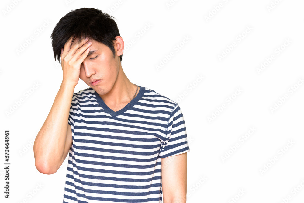 Studio shot of young stressed Asian man isolated against white background Studio shot of young stressed Asian man isolated against white background