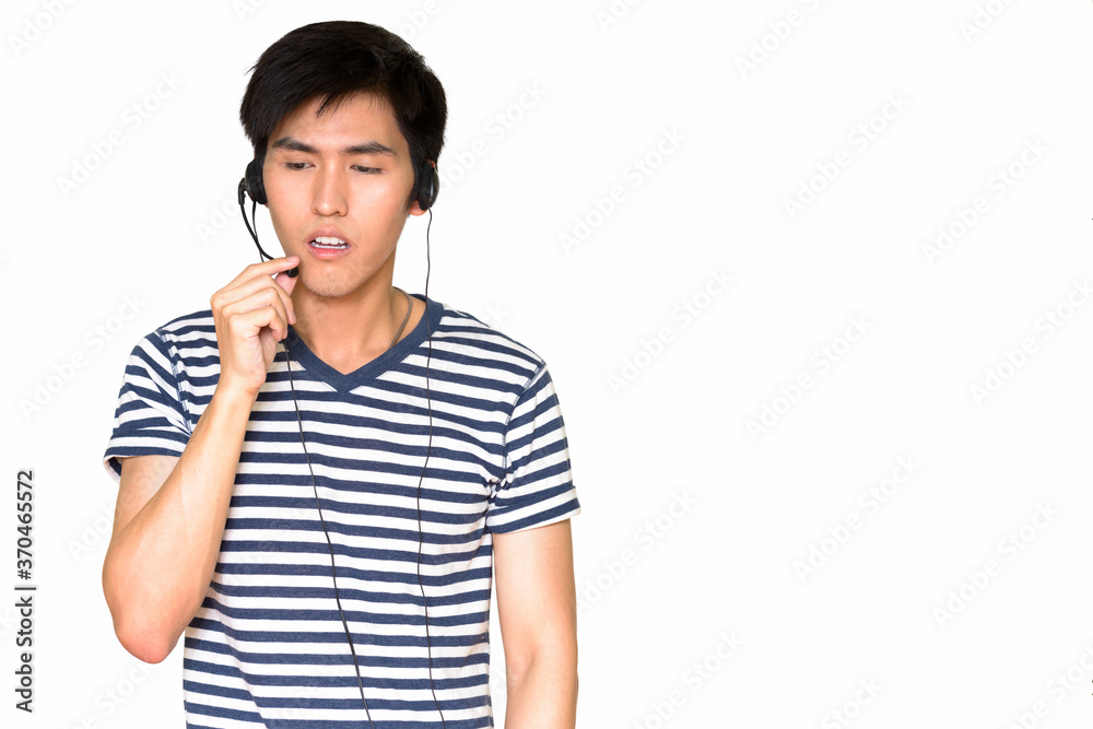 Studio shot of Asian customer service representative wearing a headset isolated against white background Studio shot of Asian customer service representative wearing a headset isolated against white background