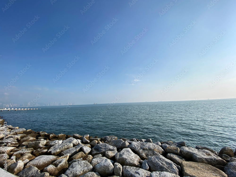 morning sunrise sea blue sky calm wave rocky shore Penang Malaysia morning sunrise sea blue sky calm wave rocky shore Penang Malaysia