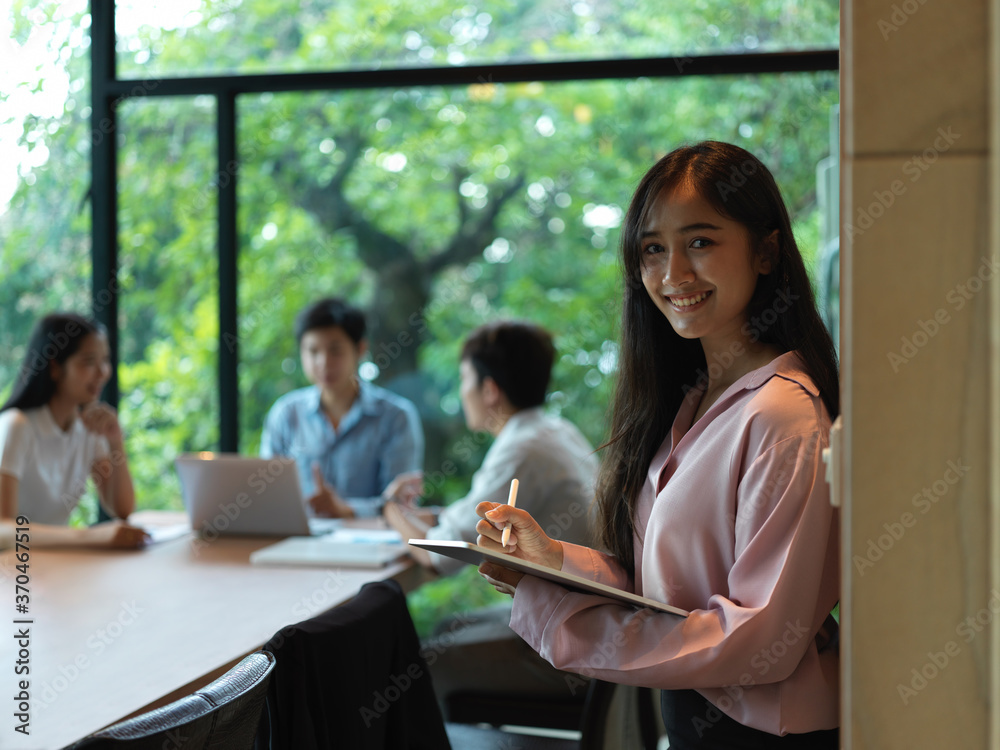 Portrait of female office worker using digital tablet while standing in meeting room Portrait of female office worker using digital tablet while standing in meeting room