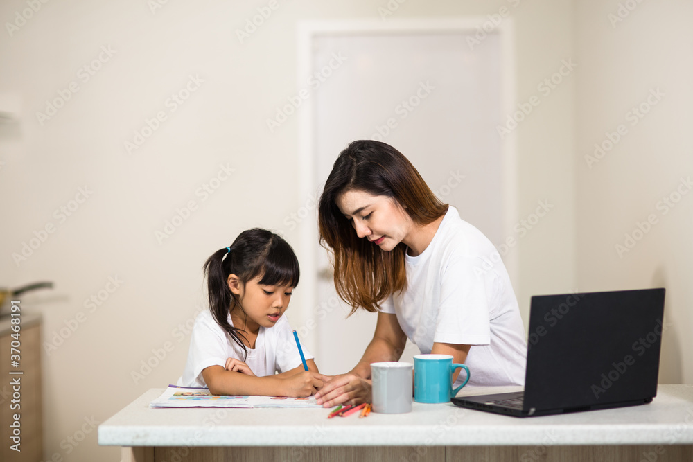 Happy mother and smiling daughter together painting using markers. Mother helping adopted child with art homework. Cheerful mother and asian little girl making painting at home. Happy mother and smiling daughter together painting using markers. Mother helping adopted child with art homework. Cheerful mother and asian little girl making painting at home.