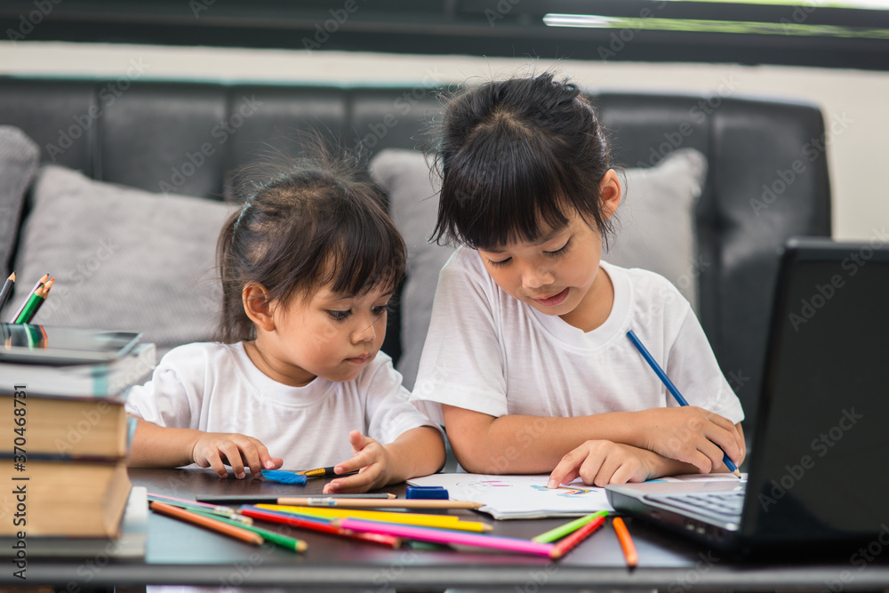 Covid-19 Coronavirus and Learning from home, Home school kid concept. Little children study online learning from home with laptop. Covid-19 Coronavirus and Learning from home, Home school kid concept. Little children study online learning from home with laptop.