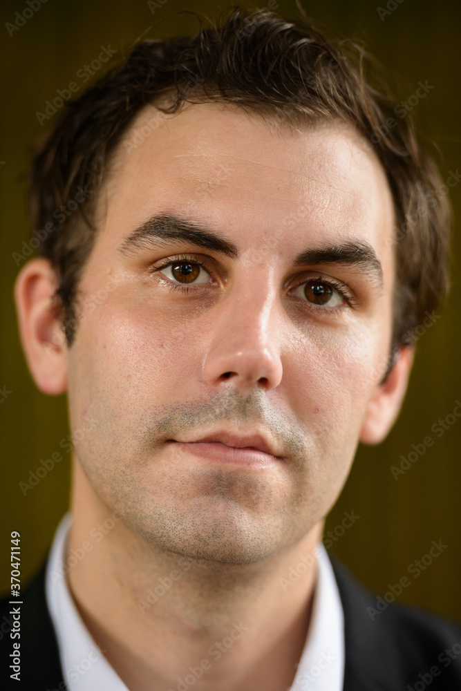 Fototapeta premium Portrait of businessman in suit against bamboo wall outdoors