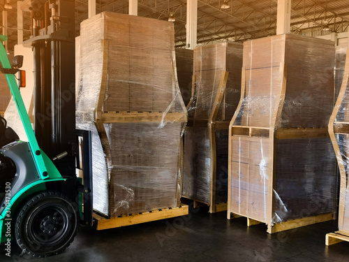 Worker driving forklift to loading and unloading wooden pallets from truck to warehouse cargo storage, shipment in logistics and transportation industrial, wood pallets stack