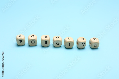 Cubes with word FORGIVE on color background