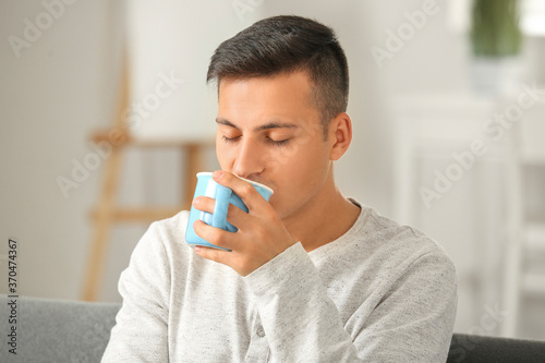 Handsome young man drinking...