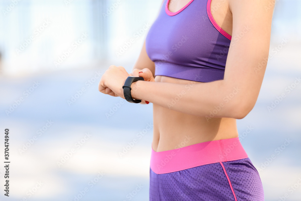 Sporty young woman with fitness tracker outdoors, closeup - obrazy, fototapety, plakaty 