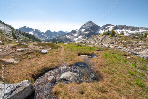 Small stream near Gwillim Lakes from above, snow, rocky terrain, Valhalla Provincial park, West Kootenays, BC