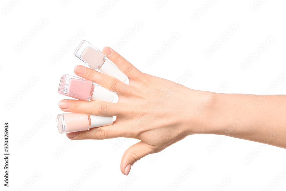 Hand with nail polishes on white background