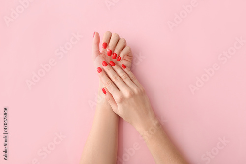 Hands with beautiful manicure on color background