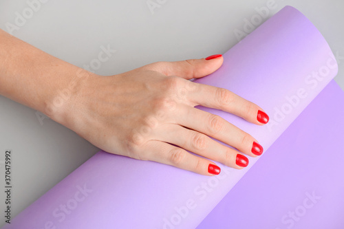 Hand with beautiful manicure on light background