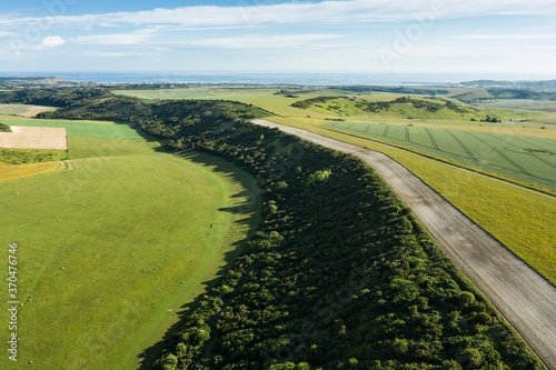 Stunning high flying drone landscape image of rolling hills in English countryside with lovely warm late evening light