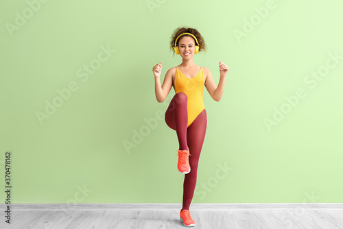 Fototapeta Naklejka Na Ścianę i Meble -  Young woman doing aerobics on color background