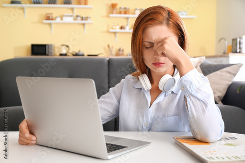 Tired woman with headphones...