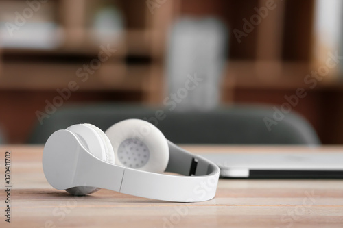 Modern headphones on table in office
