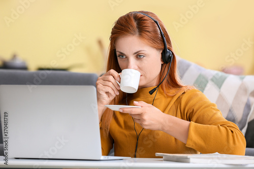 Woman with headset drinking...