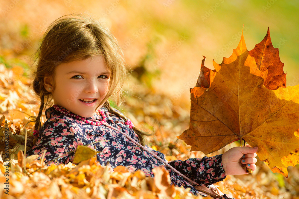 Child in the autumn park. Close-up portrait of cute little girl outdoors. Yellow maple leaves. Child in the autumn park. Close-up portrait of cute little girl outdoors. Yellow maple leaves.