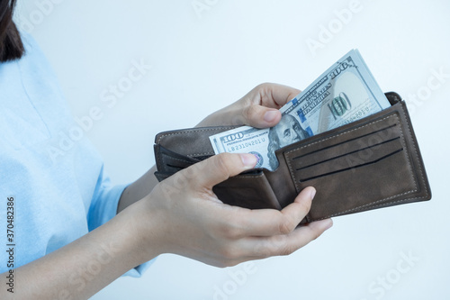 Girl holding a purse in hand put USD In a black purse calculate money to grow a successful and economical business for retirement