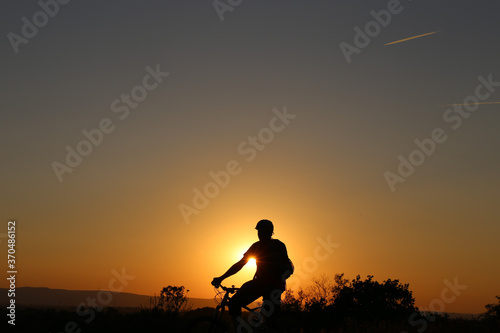 Symbolbild  Silhouette eines Mountainbikers an einem warmen Sommerabend