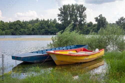 Fototapeta Naklejka Na Ścianę i Meble -  Old wooden fishing boats on a pond. Traditional small fishing boats on river bank in northern part of Serbia.