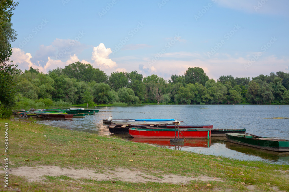 Naklejka premium Old wooden fishing boats on a pond. Traditional small fishing boats on river bank in northern part of Serbia.